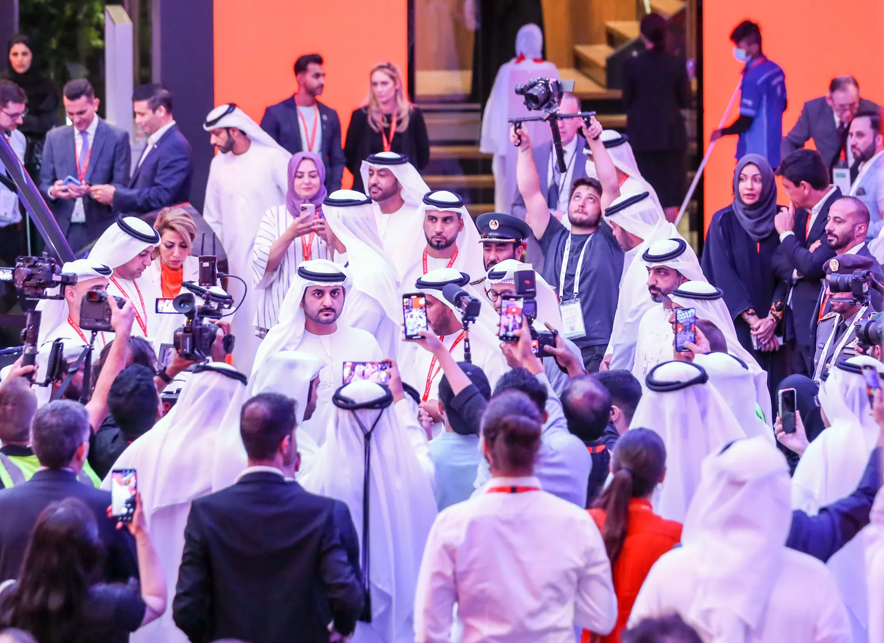 Officials and press surrounding a delegation during an opening walkabout